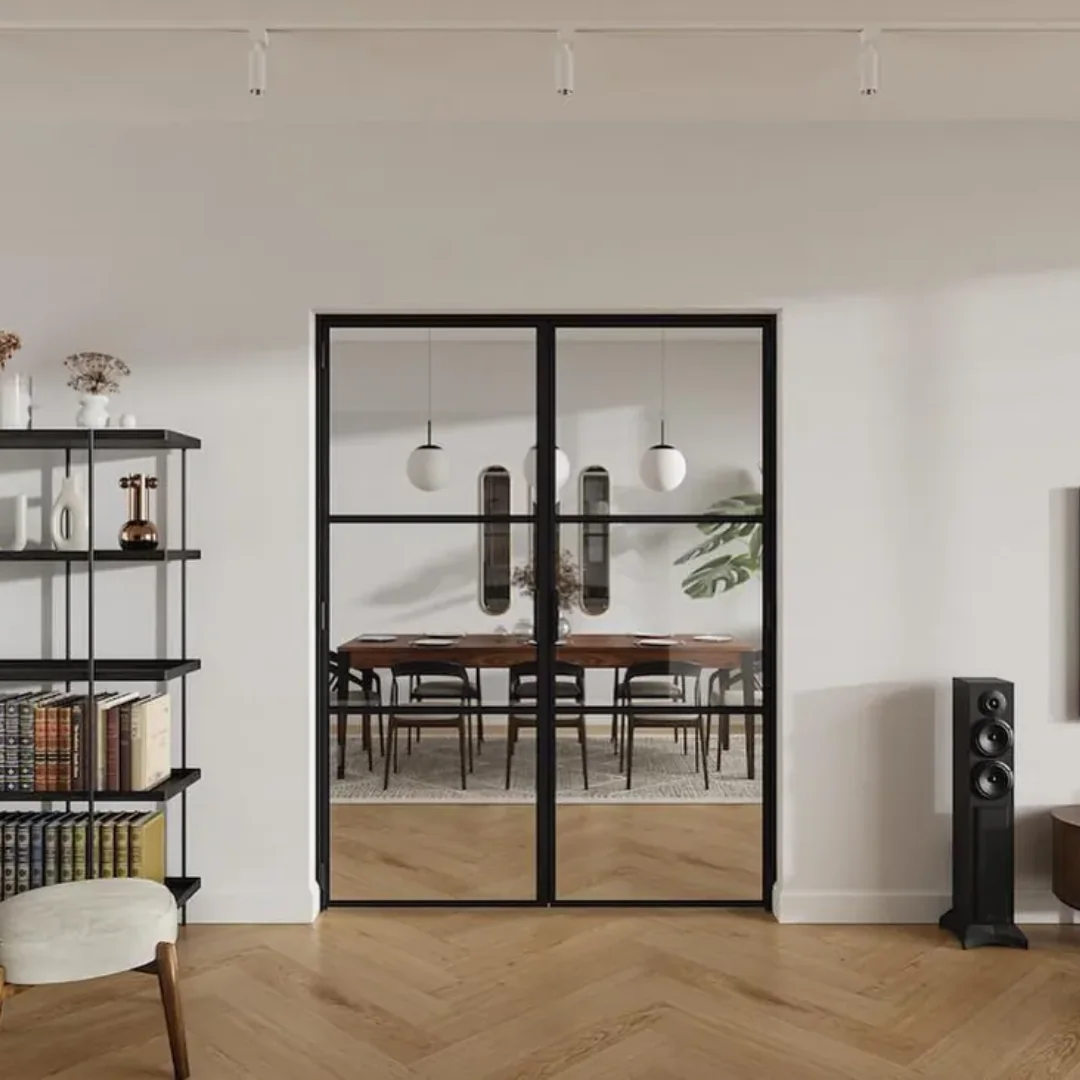 Black double loft doors opening onto a dining room