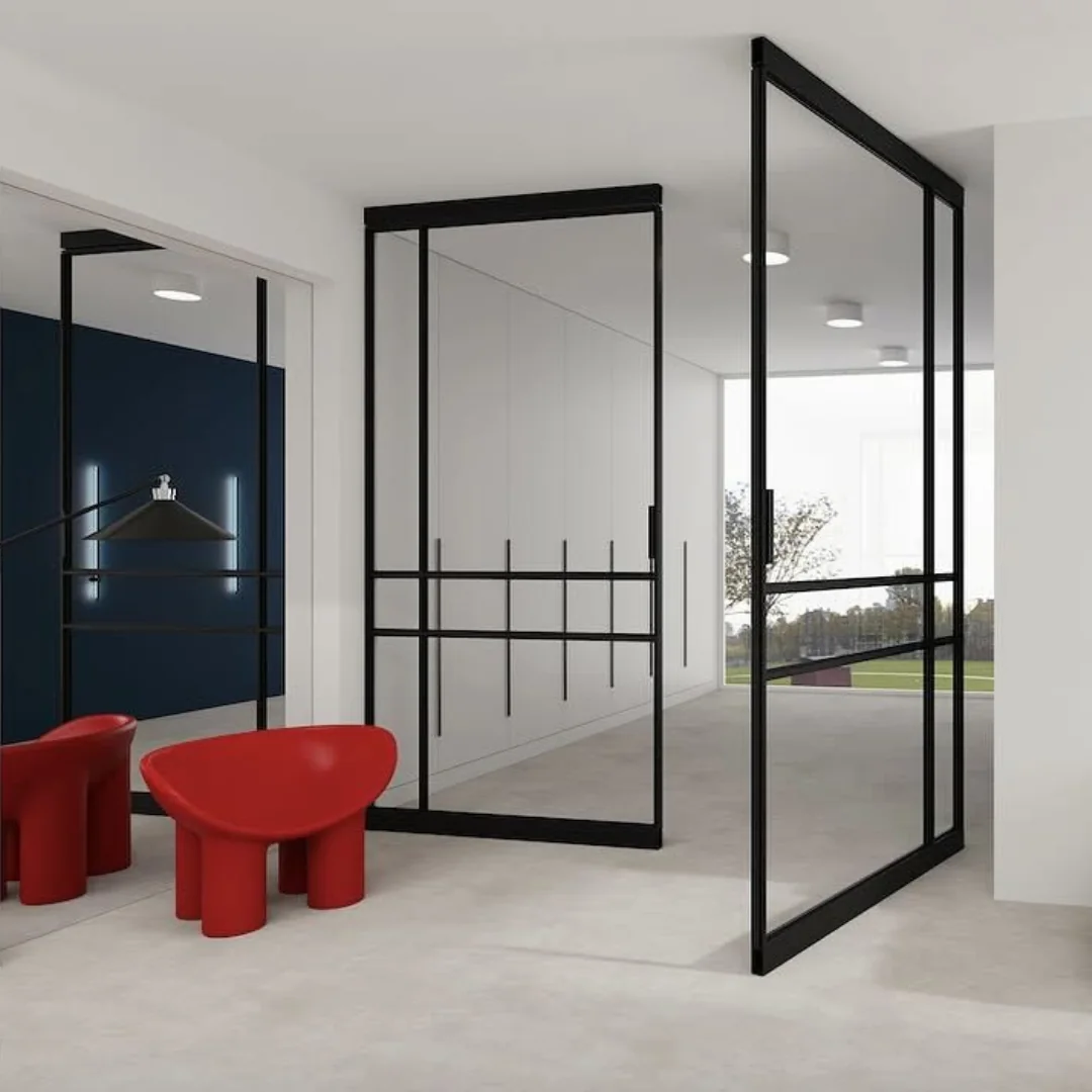 Open black pivot loft door in a bright room with red armchairs